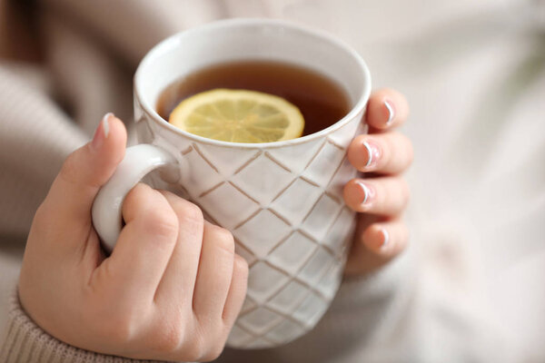 Красивая молодая женщина с чашкой горячего чая, крупным планом
