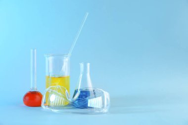 Renk arka plan üzerinde renkli örnekleri ve laboratuvar ile kimya cam ürünleri gözlükler