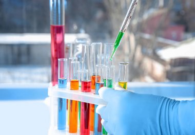 Laboratuar işçisi alarak örnek test tüp yeşil sıvı, closeup ile