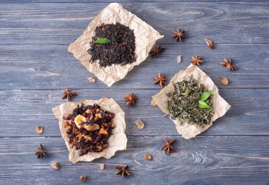 Kuru çay yaprakları ahşap arka plan üzerinde farklı tipleri ile düz yatıyordu kompozisyon