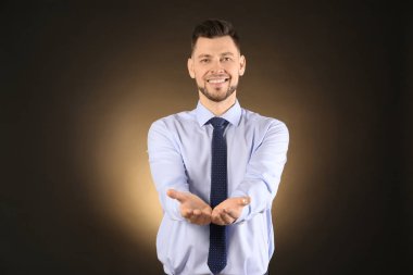 Bir şey renk arka plan üzerinde tutan genç işadamı