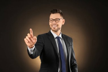 Genç işadamı renk arka plan üzerinde sanal ekran kullanma