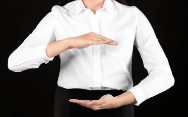 Bir şey siyah arka planda tutan genç iş kadını