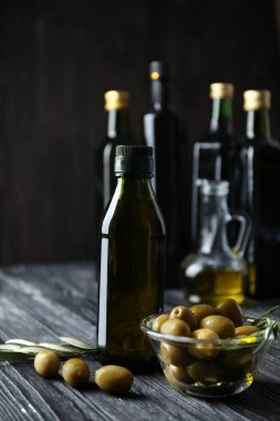 Zeytin ve şişe koyu arka plan üzerinde yağda kompozisyonu