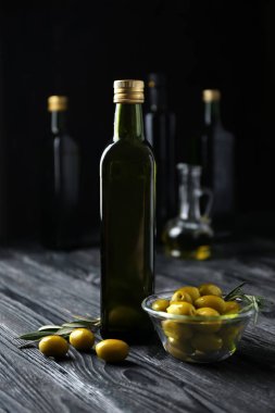 Zeytin ve şişe koyu arka plan üzerinde yağda kompozisyonu