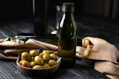 Zeytin ve şişe koyu arka plan üzerinde yağda kompozisyonu