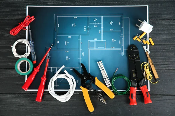 Flat lay composition with electrical tools and house plan on wooden background — Stock Photo, Image