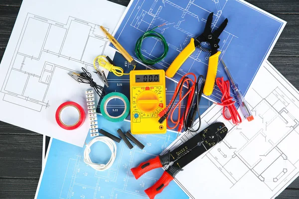 Flat lay composition with electrical tools and house plans on wooden background — Stock Photo, Image