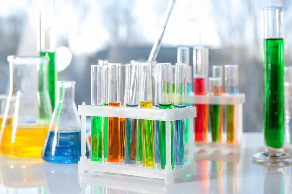 Vetreria chimica con campioni colorati sulla tavola — Foto Stock