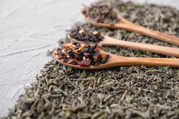 Spoon and different types of dry tea on table — Stock Photo, Image