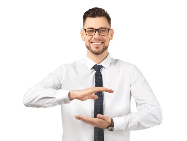 Jovem empresário segurando algo no fundo branco — Fotografia de Stock