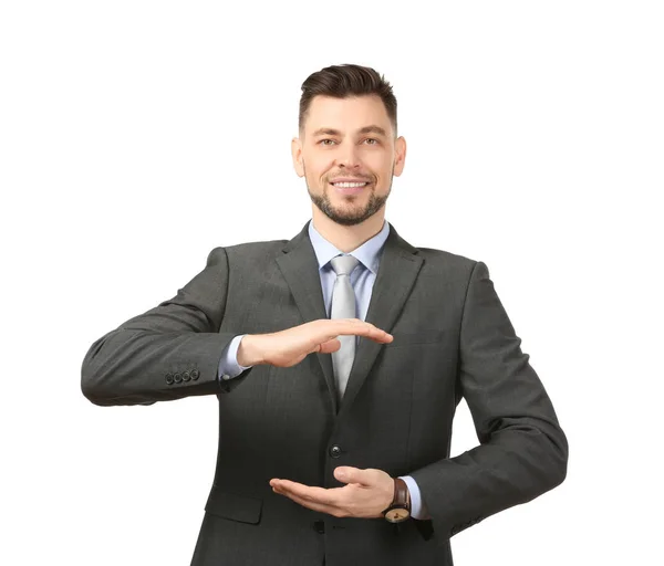 Jovem empresário segurando algo no fundo branco — Fotografia de Stock