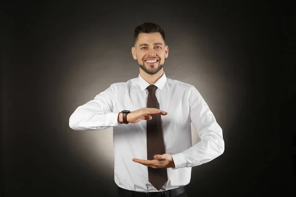 Young businessman holding something on color background — Stock Photo, Image