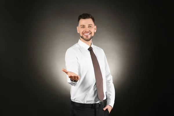 Young businessman holding something on color background — Stock Photo, Image