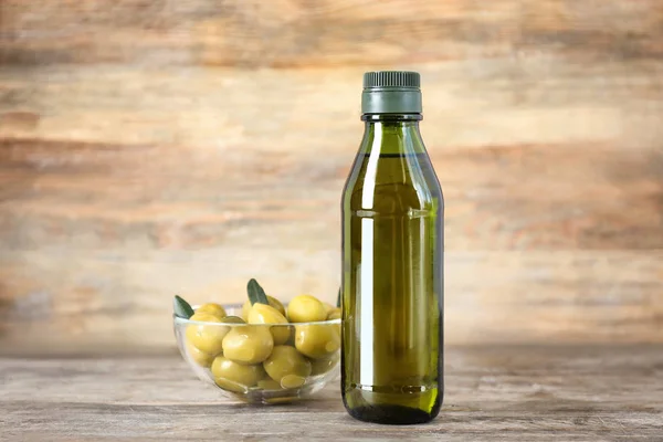 Composición con aceite de oliva en botella sobre fondo de madera — Foto de Stock