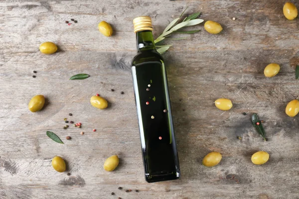 Samenstelling met olijfolie in fles op houten achtergrond, bovenaanzicht — Stockfoto