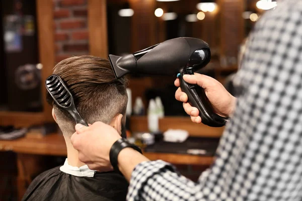 Професійний перукар, що працює з клієнтом у перукарні — стокове фото