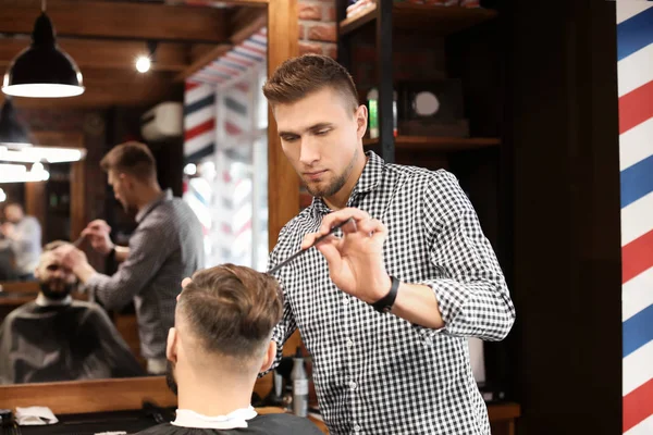 Barbier professionnel travaillant avec le client dans le salon de coiffure — Photo