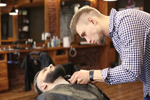 Barbier professionnel travaillant avec le client dans le salon de coiffure — Photo