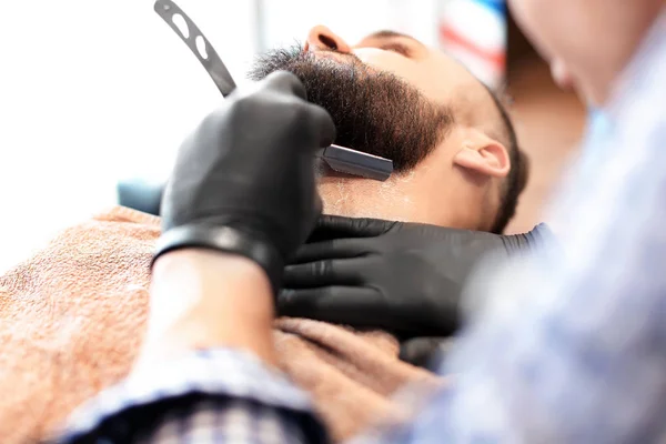 Barbeiro profissional trabalhando com o cliente no salão de cabeleireiro — Fotografia de Stock