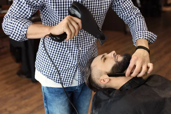 Barbeiro profissional trabalhando com o cliente no salão de cabeleireiro — Fotografia de Stock