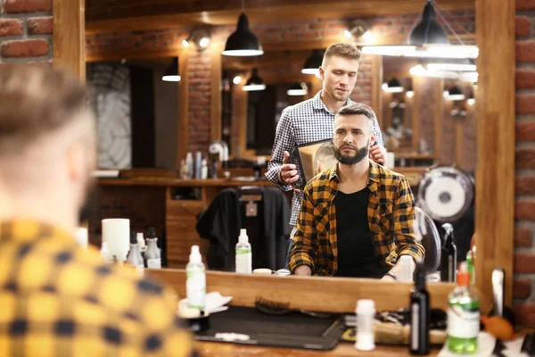 Barbier professionnel travaillant avec le client dans le salon de coiffure — Photo