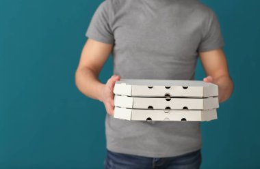 Teslimatçı renk arka plan üzerinde karton pizza kutuları ile