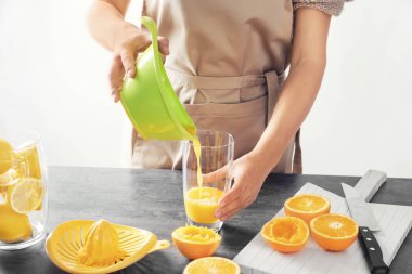 Kadın lezzetli narenciye suyu masada cam içine dökme