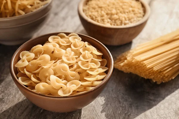 Bowl with uncooked pasta on table