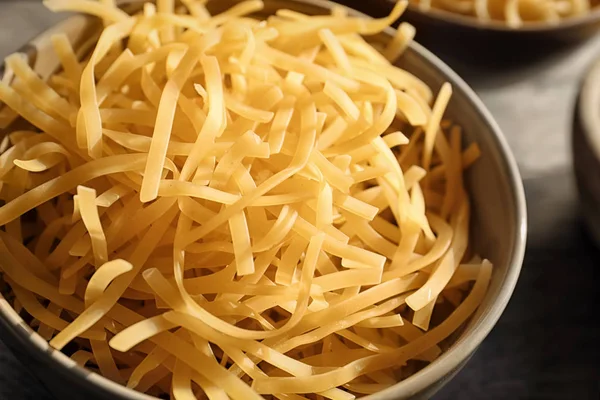 Bowl with uncooked pasta on table — Stock Photo, Image