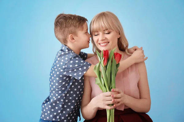Ritratto di bambino carino e sua madre con bouquet di tulipani su sfondo grigio — Foto Stock