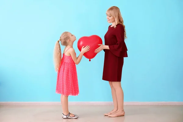 Carino bambina dando il suo palloncino madre al chiuso — Foto Stock