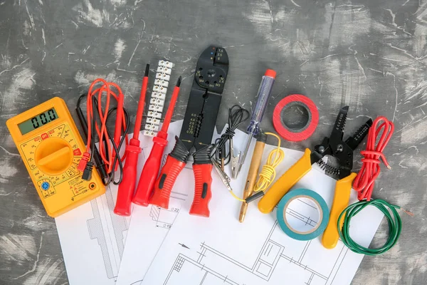 Flat lay composition with electrical tools and house plan on grey background — Stock Photo, Image