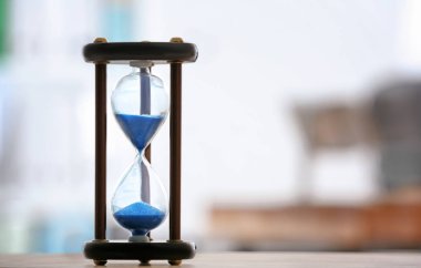 Kum saati tablo arka plan bulanık karşı. Zaman yönetimi kavramı