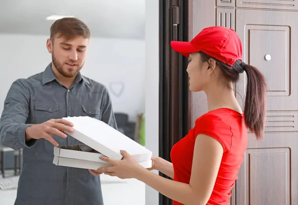 Mujer joven entregando comida al cliente en la puerta — Foto de Stock