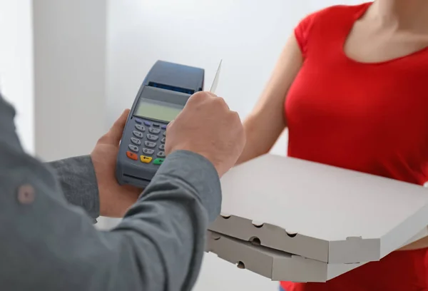 Young man using bank terminal for credit card payment at doorway. Food delivery service — Stock Photo, Image