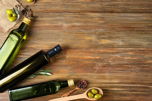 Flat lay composition with olives and oil on wooden background — Stock Photo, Image