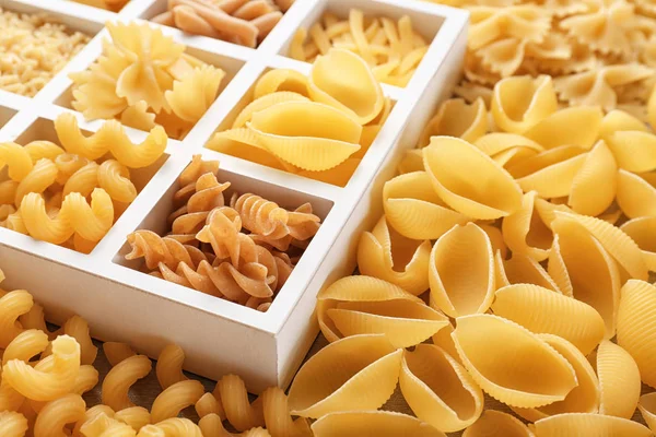 Box with different uncooked pasta, closeup