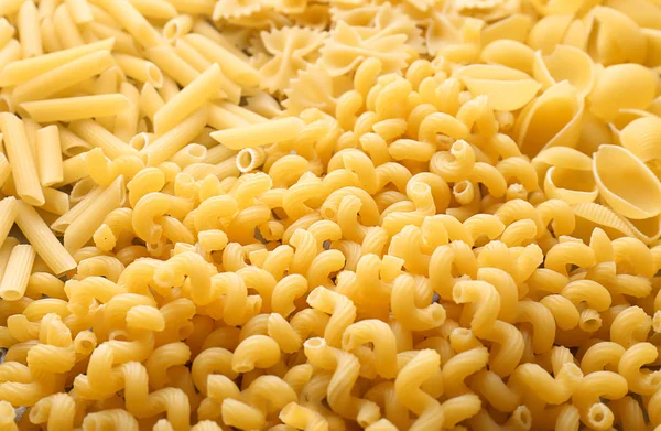 Different uncooked pasta as background, closeup — Stock Photo, Image