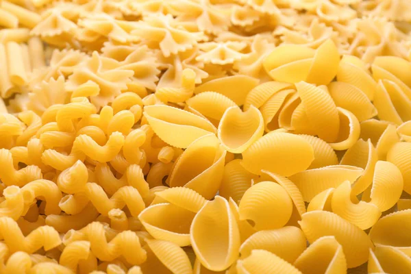 Different uncooked pasta as background, closeup — Stock Photo, Image