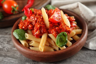 Plaka ile lezzetli penne makarna ve bolognese sosu ahşap masa, portre