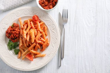 Plaka ile lezzetli penne makarna ve bolognese sosu ahşap tablo