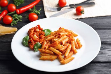 Plaka ile lezzetli penne makarna ve bolognese sosu ahşap tablo