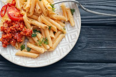 Plaka ile lezzetli penne makarna ve bolognese sosu ahşap tablo
