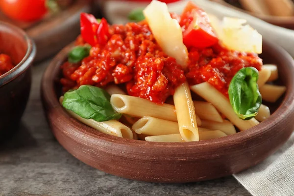 Plate with tasty penne pasta and bolognese sauce on wooden table, closeup — Stock Photo, Image