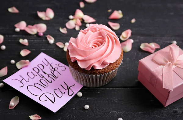 Tasty cupcake with card and gift box for Mother's day on table — Stock Photo, Image