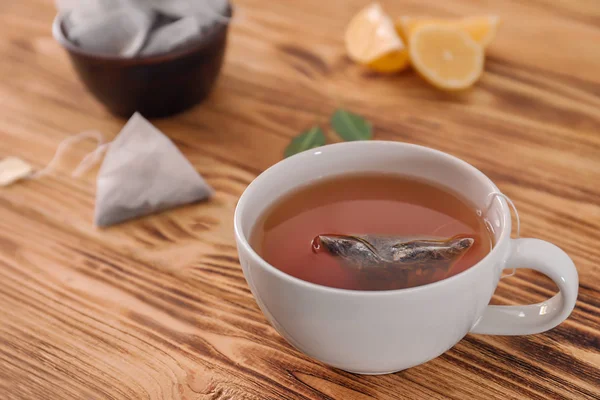 Copo com chá delicioso no fundo de madeira — Fotografia de Stock