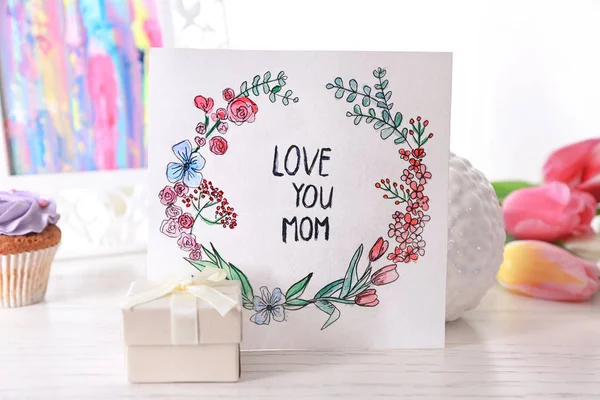 Beautiful composition with gift and handmade card for Mother's Day on white wooden table — Stock Photo, Image