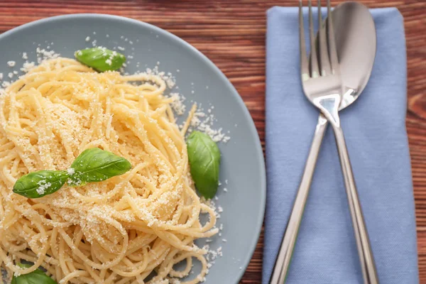 Plate with spaghetti and basil on table. Delicious pasta recipes — Stock Photo, Image