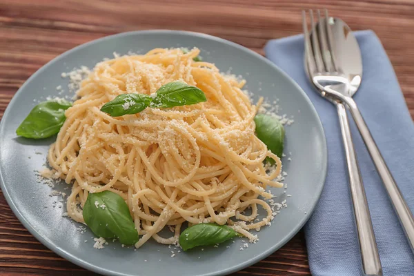 Prato com espaguete e manjericão na mesa. Deliciosas receitas de massas — Fotografia de Stock